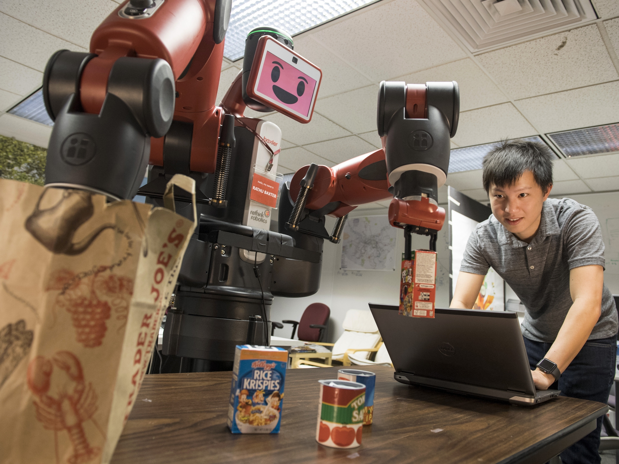 Photo of Xiang Zhi Tan, a Ph.D. student in the Robotics Institute, works with a Baxter robot, part of a multi-university research program to enable robots to assess their own performance at tasks.