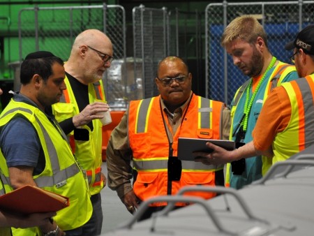 The Robotics Institute’s David Kohanbash, principal systems/software engineer, and William “Red” Whittaker, professor of robotics, discuss how a tablet can be used to launch the RadPiper uranium-detection robot with Rodrigo V. Rimando Jr., director of technology development for DOE's Office of Environmental Management, and Charles Allyn, a non-destructive assay technician with Fluor-BWXT Portsmouth.