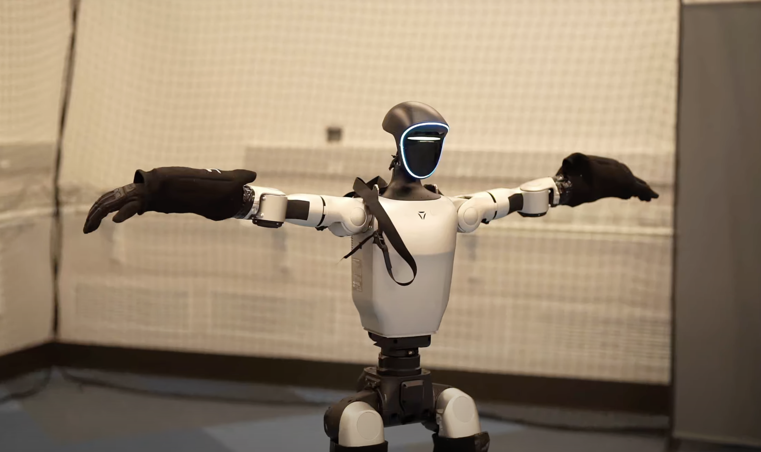 A humanoid robot stands with its arms spread open