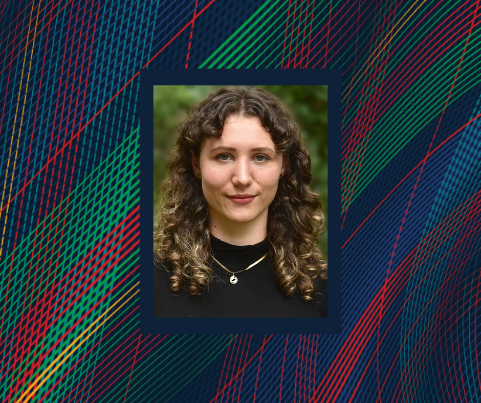 a woman with curly hair and a black shirt looks at the camera